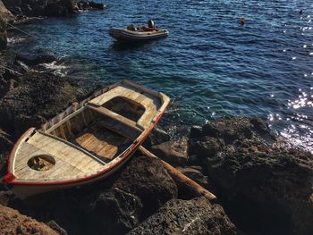 High angle view of boat on rock against sea