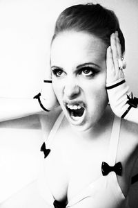 Close-up portrait of young woman against white background