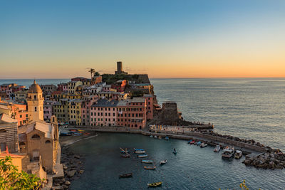 High angle view of buildings by sea against clear sky