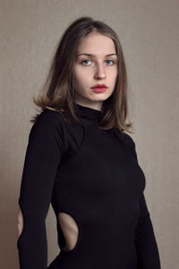Portrait of young woman young in black suit looking at the camera