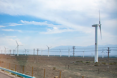 Windmills on field against sky