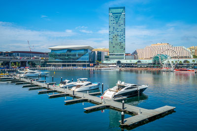 Commercial dock against buildings in city against blue sky