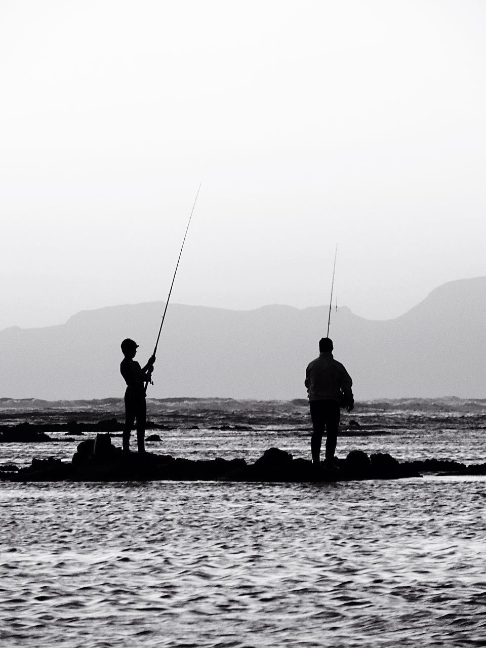 sea, water, silhouette, men, horizon over water, leisure activity, lifestyles, waterfront, scenics, beauty in nature, standing, fishing, full length, tranquil scene, tranquility, fishing rod, nature