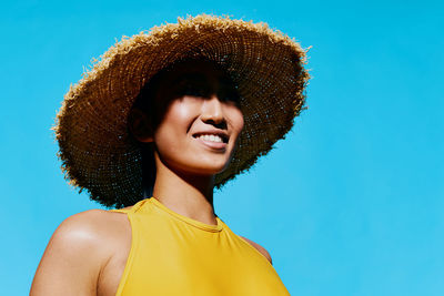 Portrait of young woman against clear blue sky