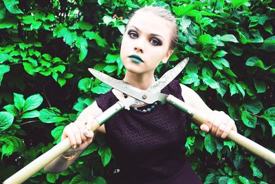 Portrait of a beautiful young woman holding plant