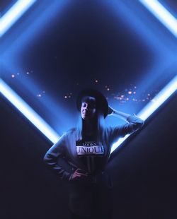 Woman standing by illuminated light