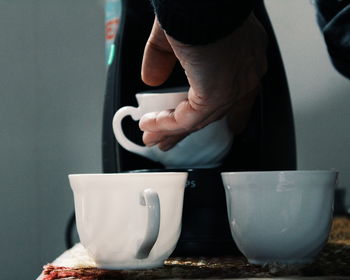 Cropped image of man hand putting cup in coffee maker