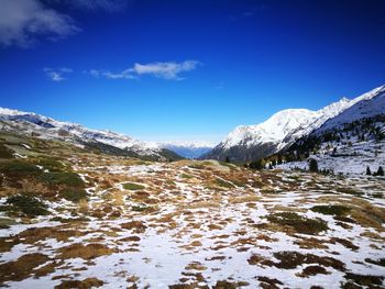 Scenic view of snowcapped mountains against blue sky