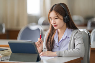 Young woman using mobile phone in office