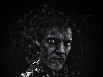 Close-up portrait of man on black background