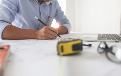 Midsection of man working on table