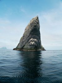 Rock formation in sea against sky