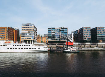 River amidst buildings in city against sky