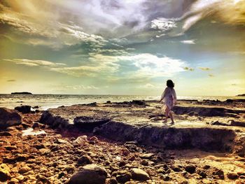 Rear view of woman standing on beach