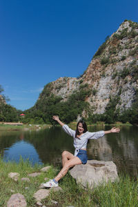 Woman standing by lake against sky