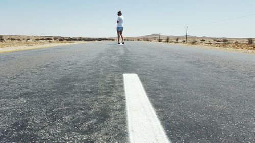 Rear view of man walking on road