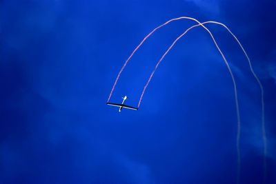 Low angle view of airplane flying against blue sky