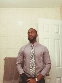 Portrait of businessman standing in bathroom