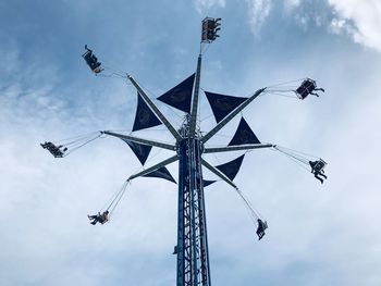 Low angle view of chain swing ride against sky