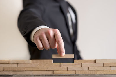 Midsection of businessman arranging wooden blocks