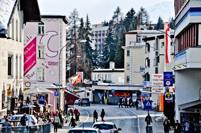 People walking on road against buildings in city