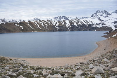 Scenic view of lake by mountains against sky