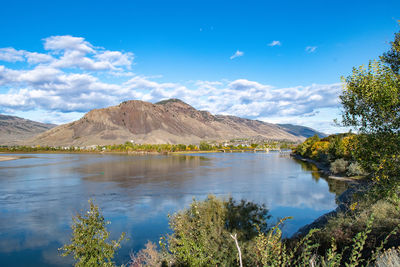 Scenic view of lake and mountains against blue sky