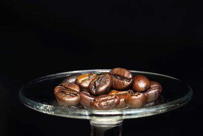 Close-up of coffee beans on table against black background