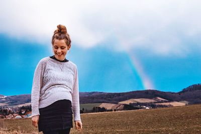 Pregnant woman standing on mountain against sky