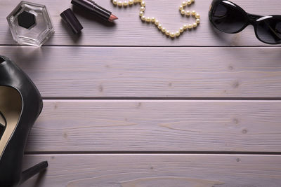 Directly above view of womenswear and beauty product on wooden table