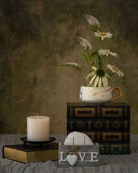 Flower vase on table against wall at home