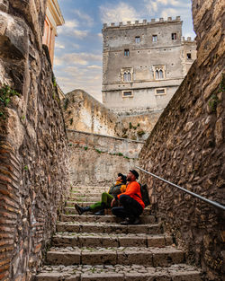 Couple sitting in a staircase with the massimo castle in the background in arsoli