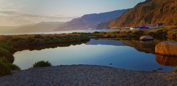 Scenic view of lake and mountains against sky