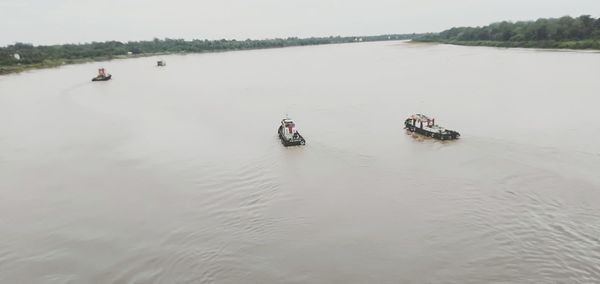 People on boat in river against sky