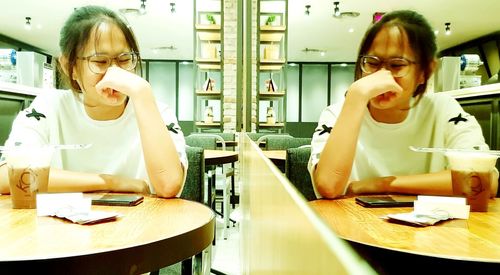 Portrait of girl sitting on table in restaurant