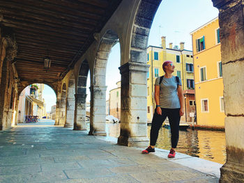 Full length of woman standing amidst buildings