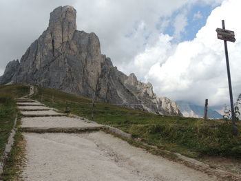 Scenic view of road by mountains against sky