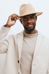 Portrait of man wearing hat against white background