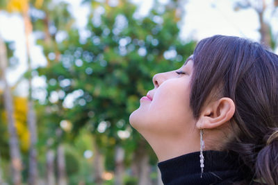 Close-up of woman with eyes closed in park