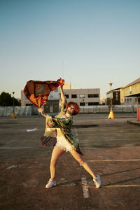 Curly redhead young female with attitude dancing in empty parking lot