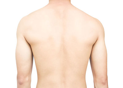 Midsection of shirtless man against white background