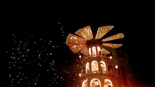 Low angle view of illuminated christmas lights against sky at night