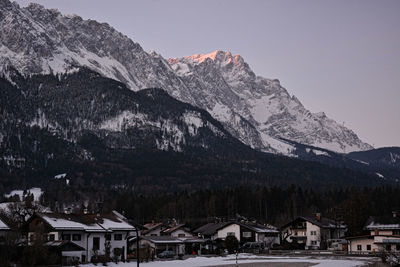 Houses on snowcapped mountains against sky