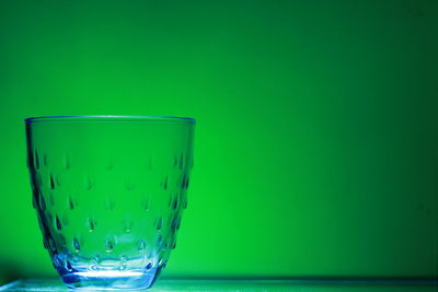 Close-up of water in glass against green background