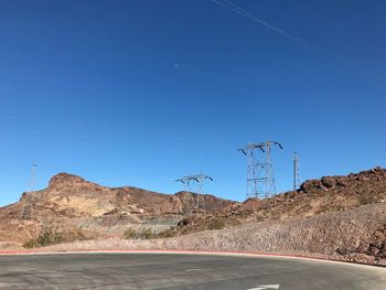 Road by mountains against clear blue sky