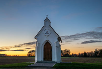 Church on field against sky during sunset