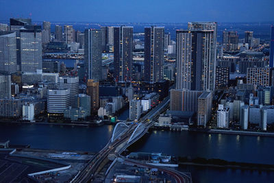 Aerial view of river amidst buildings in city