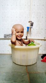 Portrait of smiling girl sitting in bathtub