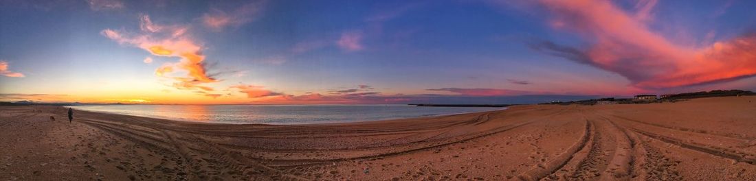 Panoramic view of beach against dramatic sky