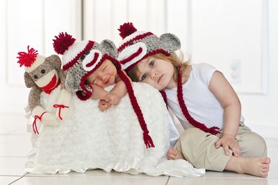 Cute siblings wearing knit hats with stuffed toy